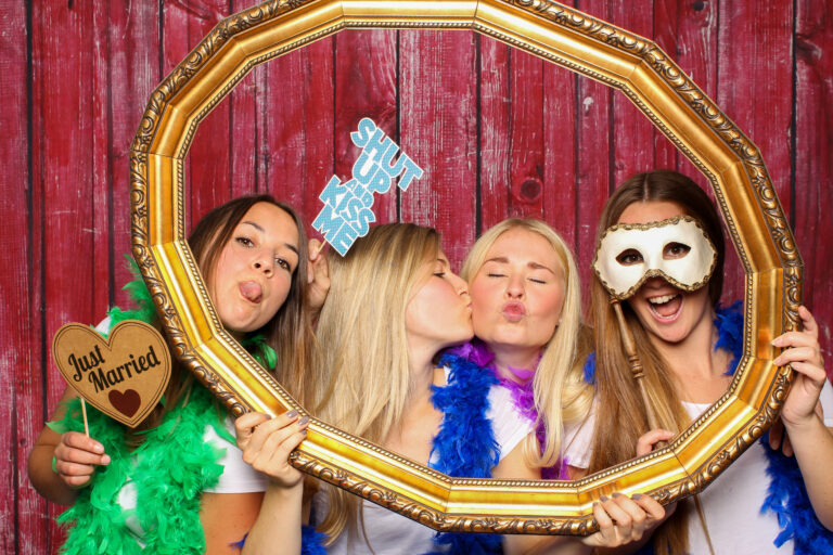 Mädchen halten Rahmen und posieren vor Fotobox -  Just Married Prob